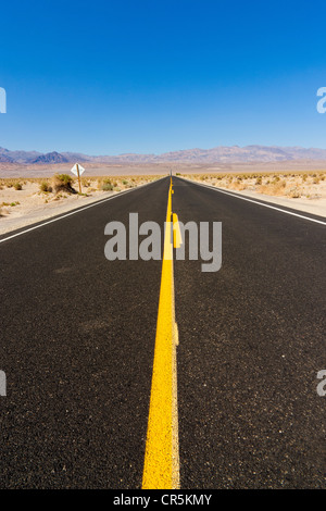 Longue ligne droite route ou autoroute s'étendant à l'infini, la Death Valley, Californie, USA. JMH5358 Banque D'Images