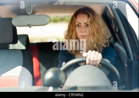 Jeune femme assise au volant d'une voiture Banque D'Images