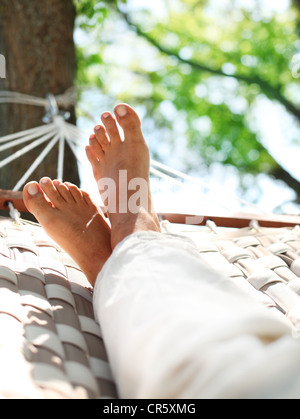 Pieds dans un hamac sur un été nature background. Banque D'Images