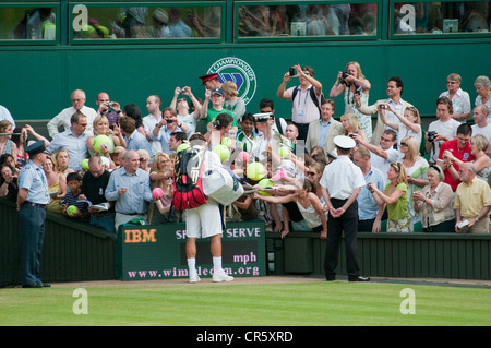 Roger Federer signer des autographes qu'il quitte le Court Central de Wimbledon, 2010. Banque D'Images