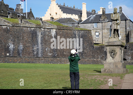 Tourisme asiatique femelle prendre des photos de la statue de Robert Bruce à l'extérieur du château de Stirling en Écosse uk Banque D'Images