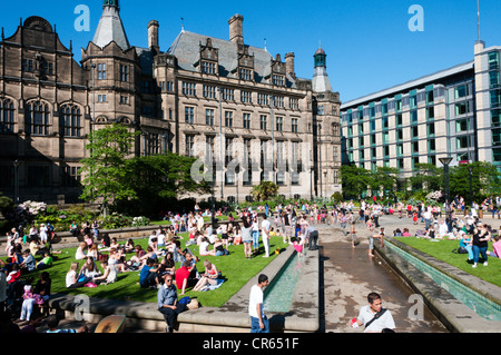 Les gens se détendre dans la chaleur de la paix jardins en face de l'hôtel de ville de Sheffield. Banque D'Images