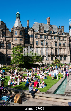 Les gens se détendre dans la chaleur de la paix jardins en face de l'hôtel de ville de Sheffield. Banque D'Images