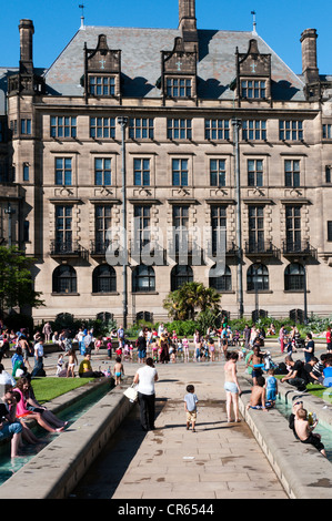 Les gens se détendre dans la chaleur de la paix jardins en face de l'hôtel de ville de Sheffield. Banque D'Images