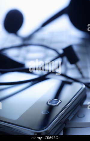 Sur le clavier de téléphone cellulaire avec casque dans office, Close up Banque D'Images