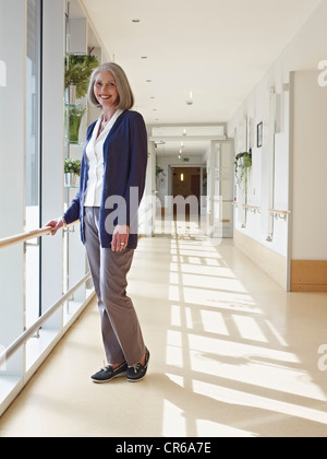 Allemagne, Cologne, Senior woman standing in corridor en maison de soins infirmiers, portrait Banque D'Images