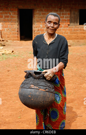 Femme tenant un récipient en terre cuite, de la production de poterie traditionnelle, Babessi, Cameroun, Afrique Banque D'Images