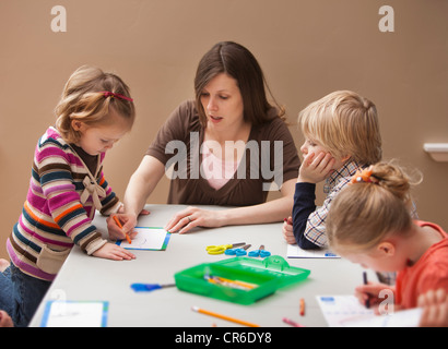 Mid adult woman enseigner aux enfants (2-3, 4-5) Dimensions de la maternelle Banque D'Images