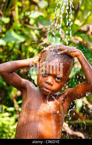 Garçon, 6, prendre une douche, Bamenda, Cameroun, Afrique Banque D'Images