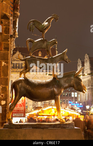 Allemagne, Bremen, Statue de Bremen City Minstrels en face du marché de Noël dans la nuit Banque D'Images