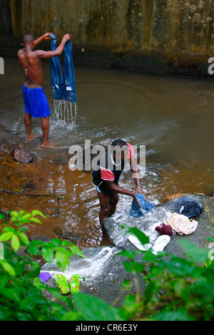 Les jeunes hommes s'en laver les jeans dans un ruisseau, Bamenda, Cameroun, Afrique Banque D'Images