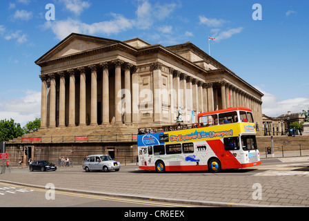 Open top bus touristique passant l'emblématique St Georges Hall, un bâtiment classé de grade 11 dans le centre-ville de Liverpool. Banque D'Images