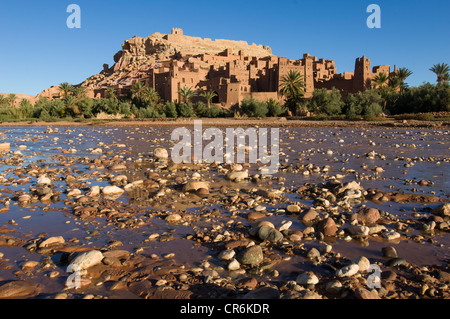 Les eaux peu profondes de la rivière en face de l'Ounila Kasbahs en ruine de la ville fortifiée (ksar) d'Ait Benhaddou, Maroc Banque D'Images