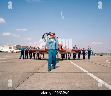 Le personnel au sol de l'ingénierie des flèches rouges, la RAF aerobatic team pousser un jet Hawk de BAE Systems en position. Banque D'Images