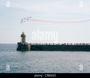 Les flèches rouges, la RAF Aerobatic Team, effectuer leur affichage public sur un mur du port foule balnéaire paysage. Banque D'Images