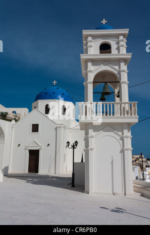Un dôme bleu sur une église peinte en blanc et une petite tour à Imerovigli, Santorini Banque D'Images