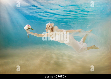 Caucasian bride in robe de natation sous l'eau Banque D'Images