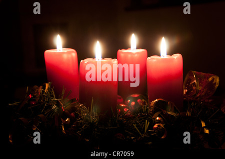 La guirlande de noël rouge avec des bougies allumées. Phares sur x-mas tree en arrière-plan Banque D'Images