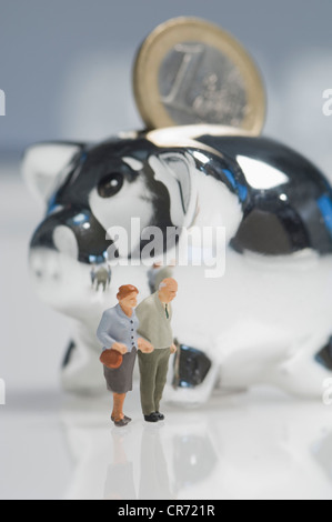 Figurines couple en plus de tirelire avec euro coin Banque D'Images