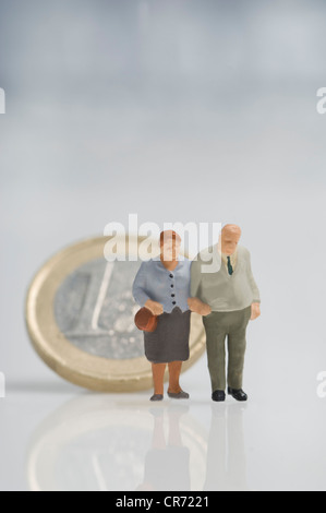 Figurines Senior couple in front of euro coins Banque D'Images