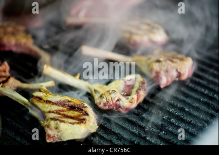 Les côtelettes d'agneau cuisson sur barbecue avec de la fumée Banque D'Images