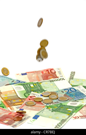 Pièces en euro tombant sur des billets en euros, image symbolique pour l'effet d'Aubaine Banque D'Images