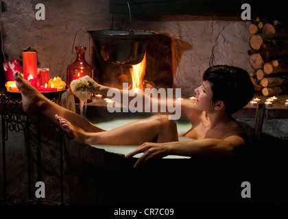 L'Autriche, Salzburg County, jeune femme prenant en baignoire à remous en bois Banque D'Images