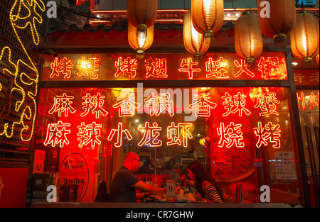 Voir en restaurant avec de nombreuses lanternes et enseignes au néon rouge sur Ghost Street en Chine Beijing Dongzhimen Banque D'Images