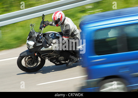 Voiture et moto dans un virage Banque D'Images