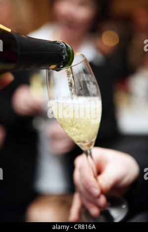 Lors d'une célébration, le champagne est versé dans un verre Banque D'Images