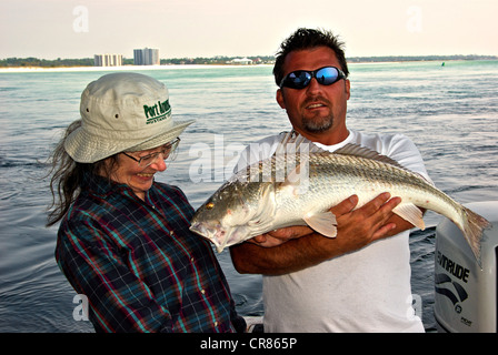 Des pêcheurs à la femelle admirer son jeu de mer côtiers de sébaste poisson qui est guide de pêche holding Perdido Pass Banque D'Images