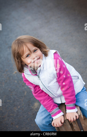 Fille, 4, assis sur une caisse en bois Banque D'Images