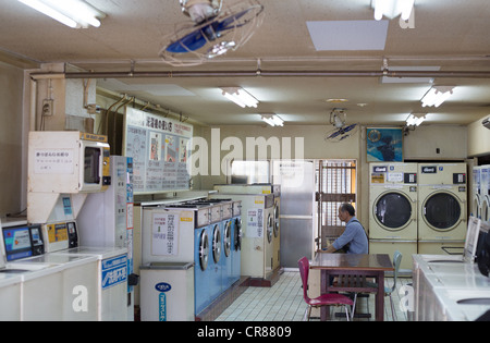 L'homme à la laverie automatique, dans le district de Shinsekai, à Osaka, région du Kansai, au Japon. Banque D'Images