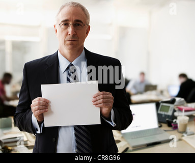 Portrait of senior man holding feuille de papier vierge Banque D'Images