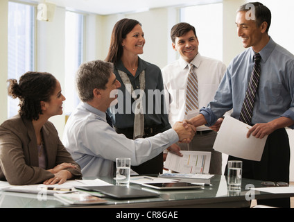 Businessman shaking hands in office avec des collègues Banque D'Images