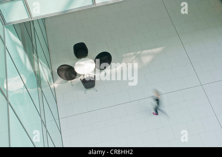 Femme marchant sur étage dans immeuble de bureau Banque D'Images