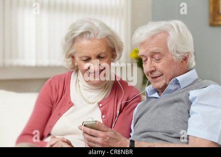 Senior couple listening to mp3 player Banque D'Images