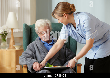 Repas à l'aide-soignant senior man Banque D'Images