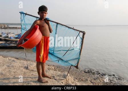 Le Bangladesh , Kalabogi Shibsha au village de la rivière à proximité du golfe du Bengale, les peuples sont plus touchés par le changement climatique, garçon avec filet de pêche pour la collecte de larves de crevettes Banque D'Images