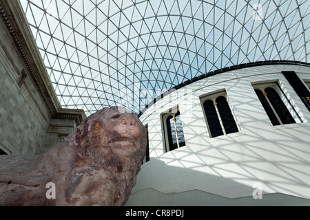 Grande cour, cour intérieure avec toit en dôme moderne, structure de verre et d'acier, et la sculpture du lion de Cnide, British Museum Banque D'Images