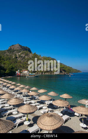 Transats et parasols sur la plage de la colline près de Fethiye, Turquie, Côte égéenne turque Banque D'Images