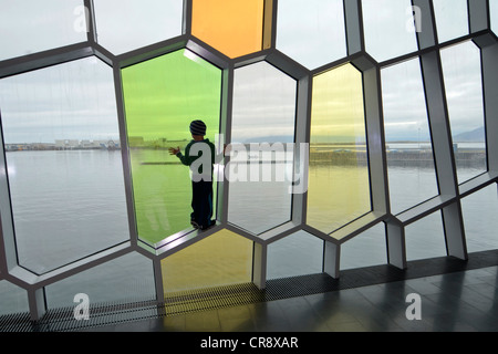 Enfant debout dans une des fenêtres en forme d'abeilles dans la façade, nouveau Harpa concert hall à Reykjavik, Islande, Europe Banque D'Images