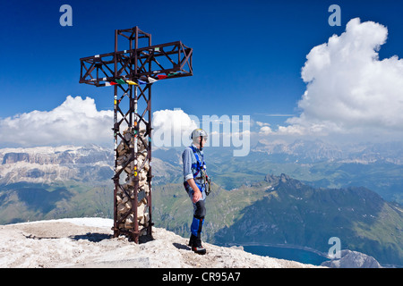 Mountaineer debout à côté de la croix au sommet de la montagne Dolomites Marmolada, col Fedaia Passo, col de montagne, Heiligkreuzkofel Banque D'Images