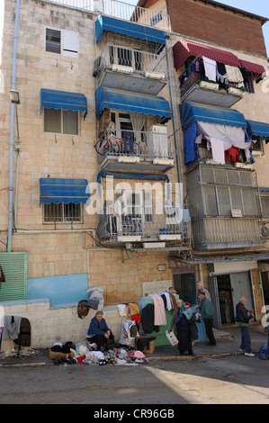 Scène de rue, femme vendant des vêtements dans la rue, maisons avec des balcons qui sont utilisés, en face de l'Mahane Banque D'Images