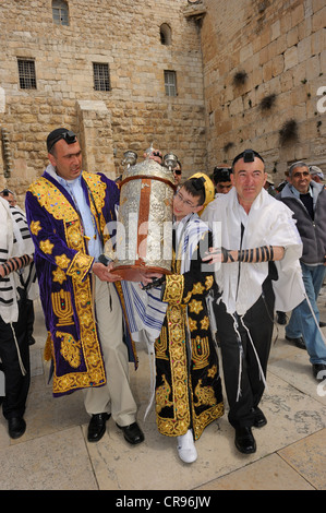 Un adolescent de 13 ans en tenue de fête, transportant une torah avec ses proches à partir de la partie souterraine du Mur des Lamentations Banque D'Images