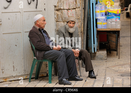 Les hommes palestiniens ayant une conversation au coin d'un bazar de la rue dans une ruelle de la Via Dolorosa, quartier arabe, Vieille Ville Banque D'Images