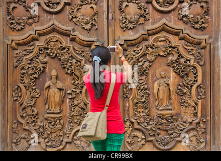 Photographier l'porte en bois finement sculptés à l'entrée de la cathédrale métropolitaine de Manille, Manille, Philippines Banque D'Images