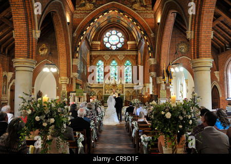 Mariée et le marié était de modifier en très coloré et ornate church dans le Berkshire Banque D'Images