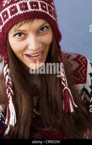 Belle jeune femme avec de grands yeux lumineux et laineux ressemble également heureux de l'appareil photo. Portrait contre un fond bleu clair Banque D'Images