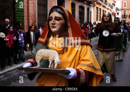 Un homme masqué vêtu comme un personnage biblique marche dans une rue au cours d'une procession de la Semaine Sainte de Pâques à Puente Genil, Espagne Banque D'Images